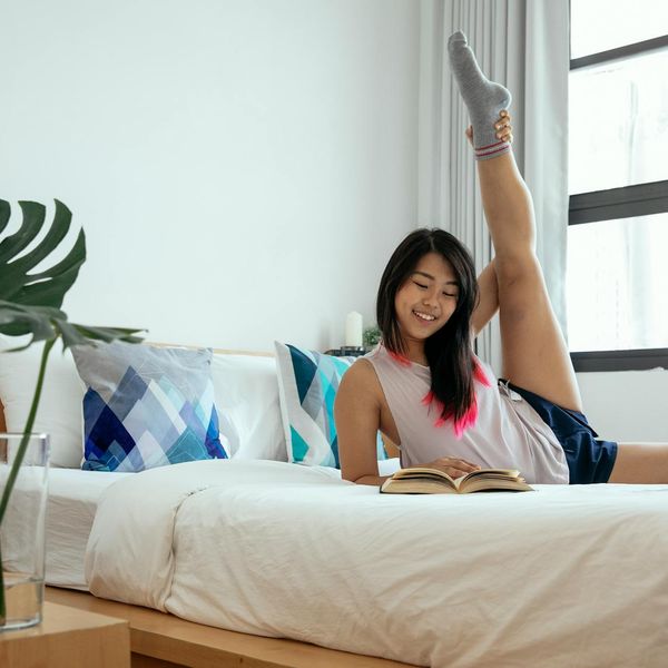 Person feeling energized and stretching towards a bright window in the morning.